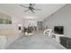 Open living room with a ceiling fan, TV, furniture, and a view to other living spaces at 7910 Sun Island S Dr # 302, South Pasadena, FL 33707