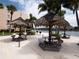 Common recreational area features tiki umbrellas and tables for outdoor dining at 7910 Sun Island S Dr # 302, South Pasadena, FL 33707