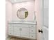 Powder room featuring a marble vanity, a decorative mirror, and a door to the side at 995 Eden Isle Ne Dr, St Petersburg, FL 33704