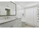 Bright bathroom featuring a marble vanity, shower, and tub with white tile surround at 995 Eden Isle Ne Dr, St Petersburg, FL 33704