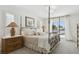 Bright bedroom boasts a wrought iron canopy bed with plush bedding and water view at 995 Eden Isle Ne Dr, St Petersburg, FL 33704