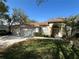 Charming home with a red tile roof, three-car garage, manicured lawn, and a beautiful arched entryway at 9131 Woodridge Run Dr, Tampa, FL 33647