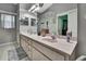 Well-lit bathroom featuring a double vanity, large mirror, and neutral decor at 11321 Copley Ct, Spring Hill, FL 34609