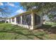 Rear exterior view of the home featuring large windows and a well-maintained lawn at 11321 Copley Ct, Spring Hill, FL 34609