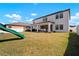 Expansive backyard with lush green grass, featuring a covered patio and play area, ideal for outdoor enjoyment at 13103 Wildflower Meadow Dr, Riverview, FL 33579