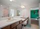 Bright bathroom featuring double sink vanity, white countertops, and large mirror at 13103 Wildflower Meadow Dr, Riverview, FL 33579