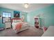 Charming bedroom featuring aqua walls, a crystal chandelier, and a cozy bed with pink accents at 13103 Wildflower Meadow Dr, Riverview, FL 33579