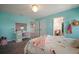 Bright bedroom featuring aqua walls, a crystal chandelier, a pink desk, and adjacent rooms visible from door way at 13103 Wildflower Meadow Dr, Riverview, FL 33579