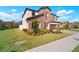Charming two-story home with a stone facade, manicured lawn and a three-car garage at 13103 Wildflower Meadow Dr, Riverview, FL 33579