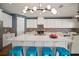 Bright kitchen with white cabinets, oversized island with seating, modern light fixture and decorative backsplash at 13103 Wildflower Meadow Dr, Riverview, FL 33579
