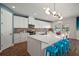 Bright kitchen with white cabinets, oversized island with seating, modern light fixture and decorative backsplash at 13103 Wildflower Meadow Dr, Riverview, FL 33579