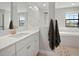 A bright main bathroom with a glass-enclosed shower, a separate soaking tub, and elegant white cabinetry at 13103 Wildflower Meadow Dr, Riverview, FL 33579