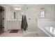 An elegant main bathroom showcasing a glass shower, soaking tub, and stylish white vanity with gray accents at 13103 Wildflower Meadow Dr, Riverview, FL 33579