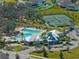This aerial photo shows a pool, recreation center, tennis courts, and playground in a desirable planned community at 13103 Wildflower Meadow Dr, Riverview, FL 33579