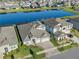 Aerial view of a spacious home with a three car garage and a screened-in pool, located in a lakefront community at 14522 Woodland Spur Dr, Lithia, FL 33547