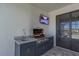 Outdoor kitchen with a stainless steel grill, granite countertops, tv, and sink under a covered patio at 14522 Woodland Spur Dr, Lithia, FL 33547