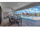 Covered outdoor patio with table, chairs, and a gorgeous view of the screened-in pool at 14522 Woodland Spur Dr, Lithia, FL 33547