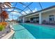 A beautifully designed pool with a screened enclosure, a covered patio area with space for outdoor dining at 14522 Woodland Spur Dr, Lithia, FL 33547