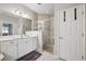 Well-lit bathroom featuring glass shower, double vanity, and soft neutral colors at 1467 Twin Villas Way, Dunedin, FL 34698