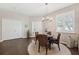 Open-concept dining area with a chandelier, wood floors, and ample natural light at 1467 Twin Villas Way, Dunedin, FL 34698