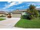 Charming single-story home featuring a two-car garage and manicured lawn at 1467 Twin Villas Way, Dunedin, FL 34698