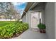 Inviting front entrance with a decorative wreath, potted plants, and lush landscaping at 1467 Twin Villas Way, Dunedin, FL 34698