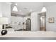 Well-lit kitchen with white cabinets, stainless steel appliances, and ample counter space at 1467 Twin Villas Way, Dunedin, FL 34698