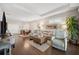 Open living space features wood floors, modern furniture, and seamlessly connects to the dining area at 1467 Twin Villas Way, Dunedin, FL 34698