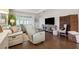 Cozy living room featuring wood floors, stylish recliners, and ample natural light at 1467 Twin Villas Way, Dunedin, FL 34698