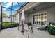 Relaxing screened-in patio with seating area, lush landscaping, and plenty of light at 1467 Twin Villas Way, Dunedin, FL 34698