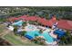 Aerial shot of community clubhouse, lagoon style pool, palm trees, lounge chairs, and well-manicured landscape at 16232 Amethyst Key Dr, Wimauma, FL 33598