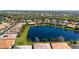 Aerial view of a neighborhood featuring a scenic lake, lush greenery, and well-maintained homes at 16232 Amethyst Key Dr, Wimauma, FL 33598