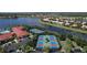 Aerial view showcasing community amenities featuring tennis, pickleball courts, parking, and a lake at 16232 Amethyst Key Dr, Wimauma, FL 33598