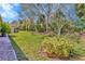 Manicured backyard with lush green grass and tropical landscaping; perfect for outdoor living at 16232 Amethyst Key Dr, Wimauma, FL 33598