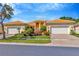 Charming single-story home with a well-manicured lawn, mature landscaping, and a three-car garage at 16232 Amethyst Key Dr, Wimauma, FL 33598