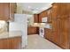 Kitchen with wood cabinetry, granite countertops, tiled backsplash, and white appliances at 16232 Amethyst Key Dr, Wimauma, FL 33598