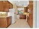 Traditional-style kitchen featuring wood cabinets, granite countertops, and white appliances at 16232 Amethyst Key Dr, Wimauma, FL 33598