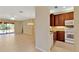 Open living area with tile floors, adjacent to a kitchen with wooden cabinets and white appliances at 16232 Amethyst Key Dr, Wimauma, FL 33598