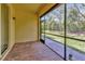 Enjoy outdoor living on this covered patio with brick flooring, offering serene views of the backyard at 16232 Amethyst Key Dr, Wimauma, FL 33598