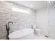 Elegant bathroom with freestanding tub, stone accent wall and modern fixtures at 163 Dolphin E Dr, Oldsmar, FL 34677