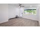 Bright bedroom with wood-look flooring, ceiling fan, and large window bringing the outside in at 163 Dolphin E Dr, Oldsmar, FL 34677