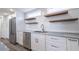 Bright kitchen featuring stainless steel appliances, white cabinets, and modern floating shelves at 163 Dolphin E Dr, Oldsmar, FL 34677