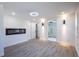 Living room boasts modern electric fireplace, recessed lights, and gray wood-look floors at 163 Dolphin E Dr, Oldsmar, FL 34677