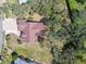 Birds-eye view of a home with a brick driveway nestled among mature trees and expansive green lawns at 18739 Bascomb Ln, Hudson, FL 34667