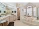 Bright bathroom with a garden tub, shower, and dual vanities at 18739 Bascomb Ln, Hudson, FL 34667