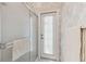 Shower with glass door and a nearby exterior door in a bathroom with floral wallpaper at 18739 Bascomb Ln, Hudson, FL 34667