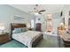 Comfortable bedroom with a ceiling fan, blue walls, and private bathroom at 18739 Bascomb Ln, Hudson, FL 34667
