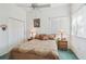 Bedroom features a comfortable bed, ceiling fan, and natural light from a window at 18739 Bascomb Ln, Hudson, FL 34667