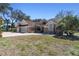 Charming single-story home featuring a three-car garage, brick accents, lush trees and meticulous landscaping at 18739 Bascomb Ln, Hudson, FL 34667