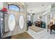 Airy foyer featuring decorative front doors, chandelier, and a view of the piano and office area at 18739 Bascomb Ln, Hudson, FL 34667